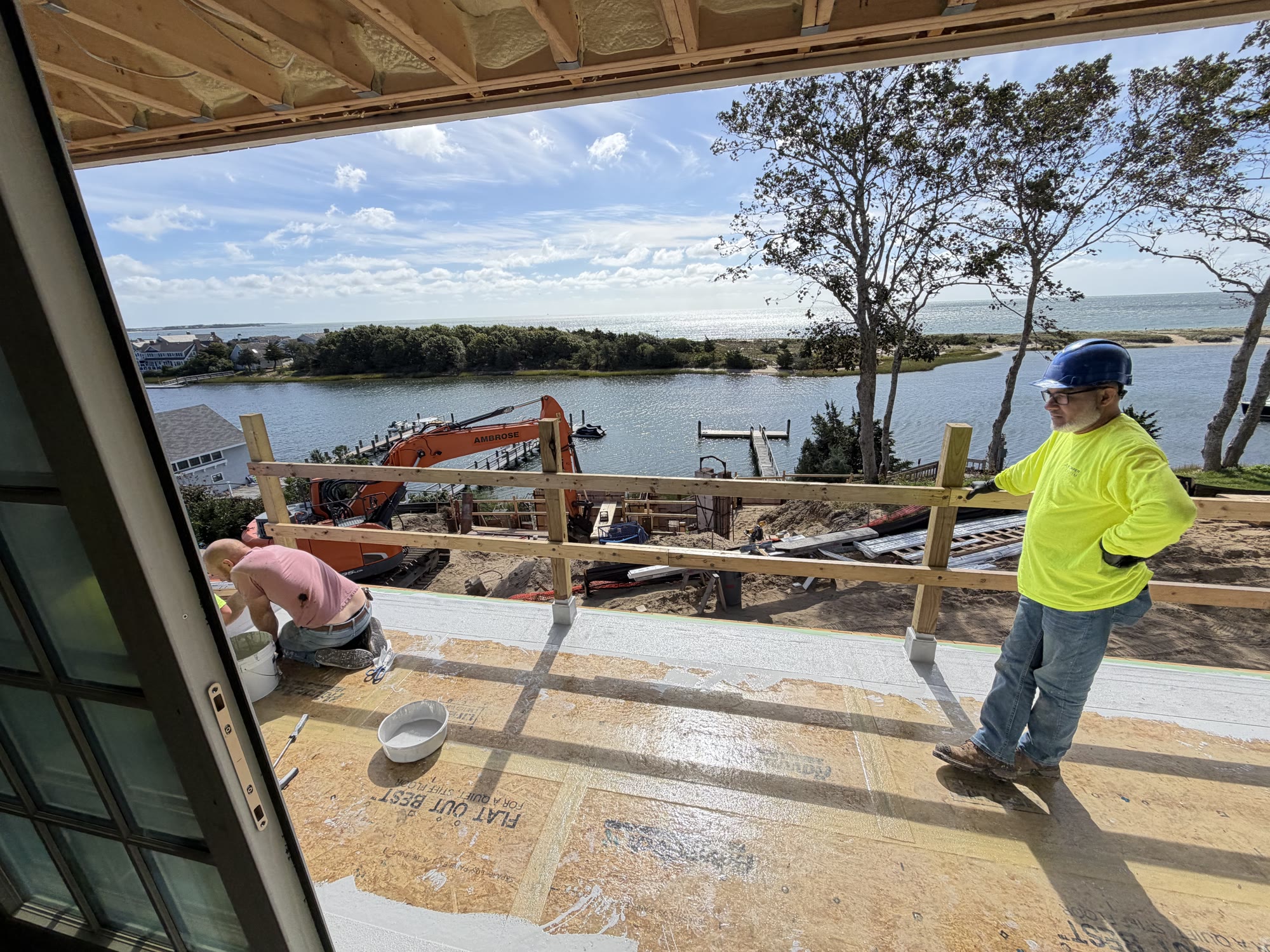 Liquid-applied waterproofing membrane installation in progress on a waterfront deck
